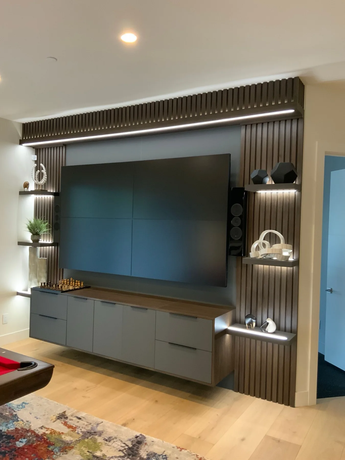 Built-in media wall with slat paneling and floating console.